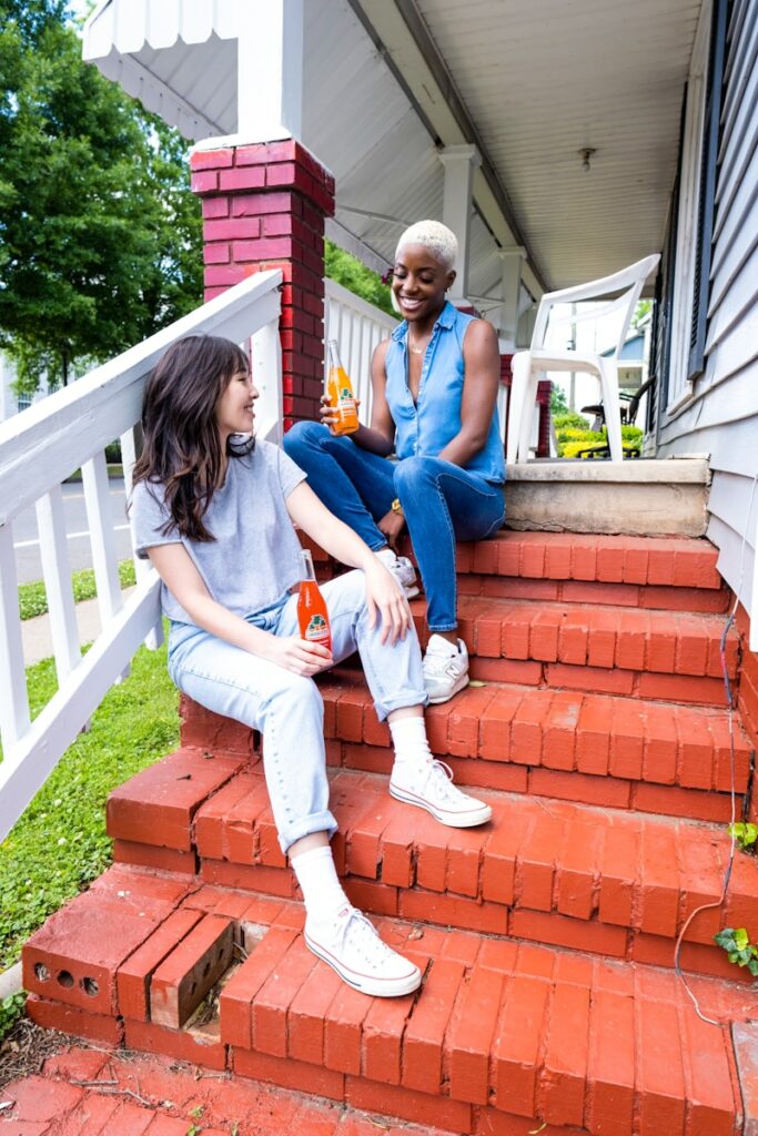 man and woman sitting on red concrete stairs